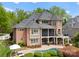 A brick home featuring an outdoor pool, patio, screened porch and mature trees at 13420 Robert Walker Dr, Davidson, NC 28036