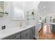 Modern bar area featuring white subway tile and gray cabinets and an adjacent kitchen at 13420 Robert Walker Dr, Davidson, NC 28036