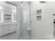 Clean and sleek bathroom featuring a glass shower, tiled walls, and modern fixtures and lighting at 13420 Robert Walker Dr, Davidson, NC 28036