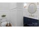Elegant half-bathroom featuring a navy blue vanity with marble countertop and decorative wallpaper at 13420 Robert Walker Dr, Davidson, NC 28036