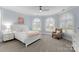 Serene bedroom with plush chair, arched windows, and neutral tones for a relaxing retreat at 13420 Robert Walker Dr, Davidson, NC 28036