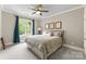Cozy bedroom featuring a large window, blue curtains, and a decorative ceiling fan for added comfort at 13420 Robert Walker Dr, Davidson, NC 28036