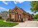A brick house boasts a three-car garage and manicured landscaping in a circular driveway at 13420 Robert Walker Dr, Davidson, NC 28036