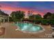 Custom-shaped pool with stone surround, integrated spa, and lush landscaping with brick paver patio at 13420 Robert Walker Dr, Davidson, NC 28036