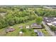 Aerial view revealing a property surrounded by lush trees, a road, and neighboring buildings at 15 Willow Oaks Ct, Taylorsville, NC 28681
