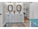 Bright bathroom featuring double vanity with decorative mirrors, ample storage, and neutral color scheme at 15 Willow Oaks Ct, Taylorsville, NC 28681