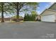 Property with a large driveway, lush landscaping, and mature trees offering ample parking and curb appeal at 15 Willow Oaks Ct, Taylorsville, NC 28681