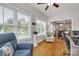 Bright sunroom featuring large windows, hardwood floors, and comfortable seating next to the open kitchen at 15 Willow Oaks Ct, Taylorsville, NC 28681