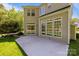 View of the home's rear featuring a concrete patio and large windows overlooking the landscaped backyard at 15002 Strathmoor Dr, Charlotte, NC 28277