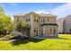 A backyard featuring green grass, stone landscaping beds, a stone paver walkway, a patio, and a two story home at 15002 Strathmoor Dr, Charlotte, NC 28277