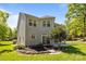 A backyard featuring green grass, stone landscaping beds, a stone paver walkway, a patio, and a two story home at 15002 Strathmoor Dr, Charlotte, NC 28277