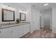 Bathroom with double vanity sinks, granite counters, wood flooring, and a door leading to a shower at 15002 Strathmoor Dr, Charlotte, NC 28277