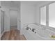 Bright bathroom featuring a large soaking tub by a window, a tiled floor, and a glass-enclosed shower at 15002 Strathmoor Dr, Charlotte, NC 28277