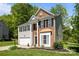 Two-story home with a blend of brick and vinyl siding, attached garage, and landscaped front yard at 15002 Strathmoor Dr, Charlotte, NC 28277