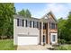 Inviting two-story home with brick and vinyl exterior, attached two-car garage, and manicured front yard at 15002 Strathmoor Dr, Charlotte, NC 28277