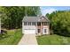 Charming two-story home with brick and vinyl siding, lush green lawn, and a two-car garage at 15002 Strathmoor Dr, Charlotte, NC 28277
