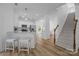 Open concept kitchen with barstool seating opens up to a stairway with wood trim and carpeted stairs at 15002 Strathmoor Dr, Charlotte, NC 28277