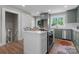 Kitchen with sleek stainless steel appliances, white countertops, custom sage green cabinets, and an island with seating at 155 Jackson Rd, Salisbury, NC 28146