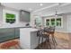 Modern kitchen featuring an island with barstool seating, custom sage green cabinets, and access to the living area at 155 Jackson Rd, Salisbury, NC 28146