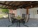 A cozy outdoor dining area features a table with four chairs under a covered space, perfect for enjoying meals al fresco at 155 Jackson Rd, Salisbury, NC 28146