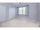 Neutral bedroom featuring a window with curtains, a double-door closet, and neutral carpeting at 1716 Termini Dr, Charlotte, NC 28262