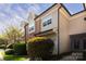 Charming townhome displaying neutral siding and brick accents, complemented by manicured bushes and lush green lawn at 1716 Termini Dr, Charlotte, NC 28262