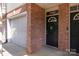 Charming townhome with a black front door adorned with a wreath and a convenient attached garage at 1716 Termini Dr, Charlotte, NC 28262