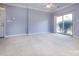 Bright living room boasting neutral paint, carpeted floors, a ceiling fan, and sliding glass doors at 1716 Termini Dr, Charlotte, NC 28262