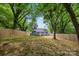 View of the blue home and backyard area with a wooden deck framed by mature shade trees at 1913 Garibaldi Ave, Charlotte, NC 28208