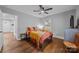 Comfortable bedroom featuring hardwood floors, a ceiling fan, and a large window for plenty of natural light at 1913 Garibaldi Ave, Charlotte, NC 28208