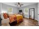 Cozy bedroom features hardwood floors, a ceiling fan, and abundant natural light from the large windows at 1913 Garibaldi Ave, Charlotte, NC 28208