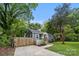 Charming blue home with a well-manicured lawn, mature trees and a welcoming yellow front door at 1913 Garibaldi Ave, Charlotte, NC 28208