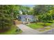 Charming blue home boasts a yellow front door, green lawn, and a long concrete driveway at 1913 Garibaldi Ave, Charlotte, NC 28208