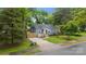 Charming blue home with a yellow front door and mature landscaping is shown from the curb at 1913 Garibaldi Ave, Charlotte, NC 28208