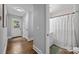 Hallway view with modern door and bathroom featuring patterned shower curtain and neutral tiling at 1913 Garibaldi Ave, Charlotte, NC 28208