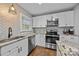 Well-lit kitchen features granite countertops, stainless steel appliances, white cabinetry, and herringbone backsplash at 1913 Garibaldi Ave, Charlotte, NC 28208