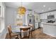 Bright kitchen with adjacent dining featuring granite countertops, stainless appliances, white cabinets, and herringbone backsplash at 1913 Garibaldi Ave, Charlotte, NC 28208
