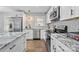 Modern kitchen with stainless steel appliances, white cabinets, granite countertops, and herringbone backsplash at 1913 Garibaldi Ave, Charlotte, NC 28208