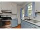 Charming kitchen with stainless steel stove, subway tile backsplash, and blue cabinets at 1944 Garibaldi Ave, Charlotte, NC 28208