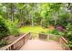 Expansive backyard view from the deck, featuring a lush lawn, mature trees, and a fire pit area at 19729 Callaway Hills Ln, Davidson, NC 28036