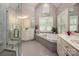 Luxurious bathroom with a soaking tub, glass shower, and dual vanities at 19729 Callaway Hills Ln, Davidson, NC 28036