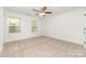 Spacious bedroom with two windows, a ceiling fan, and neutral carpet for a comfortable atmosphere at 213 Rosemont Ave, Kannapolis, NC 28081