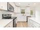 Well-lit kitchen featuring sleek stainless steel appliances, pristine white countertops, and ample cabinet space for storage at 213 Rosemont Ave, Kannapolis, NC 28081