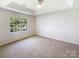 Spacious bedroom featuring carpet flooring, tray ceilings, and a sunny window at 2405 Kalis Pl, Charlotte, NC 28262