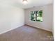 Clean bedroom with carpeted floor and window to the backyard at 2405 Kalis Pl, Charlotte, NC 28262