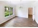 Dining room featuring hardwood floors, modern light fixture, and scenic backyard view at 2405 Kalis Pl, Charlotte, NC 28262