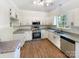 Bright kitchen featuring white cabinets, granite countertops, and stainless steel appliances at 2405 Kalis Pl, Charlotte, NC 28262