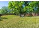 Large, fenced backyard with a fire pit, offering ample green space and privacy at 2601 Dora Dr, Charlotte, NC 28215