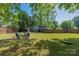 Large backyard featuring a lush lawn, fire pit area with seating, and perimeter fencing at 2601 Dora Dr, Charlotte, NC 28215