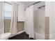 Bathroom featuring a shower with white tiling, a window, and neutral accents at 2601 Dora Dr, Charlotte, NC 28215